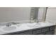 Well-lit bathroom featuring a double sink vanity with gray cabinetry and white marble countertops at 4252 Parkview Ct, Stone Mountain, GA 30083