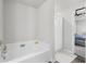 Bright bathroom featuring a soaking tub, a shower, and a doorway to a bedroom at 9122 Golfview Cir, Covington, GA 30014