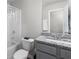 Well-lit bathroom with gray cabinets, granite countertop, and shower over tub at 9122 Golfview Cir, Covington, GA 30014