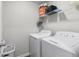 Bright laundry room features a washer, dryer, and shelving for storage at 9122 Golfview Cir, Covington, GA 30014