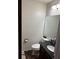 Cozy half-bathroom featuring a sink with dark cabinets, toilet, and neutral paint color at 1110 Country Ct, Lawrenceville, GA 30044