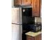 Kitchen with stainless steel refrigerator, dark wood cabinets, and granite countertops at 1110 Country Ct, Lawrenceville, GA 30044