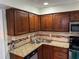 Kitchen showcasing dark wood cabinets, granite countertop and tile backsplash at 1110 Country Ct, Lawrenceville, GA 30044