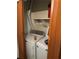 Convenient laundry area with a washer, dryer, wire shelving, and orange bi-fold doors at 1110 Country Ct, Lawrenceville, GA 30044