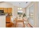 Bright dining area with modern white chairs, wood table, large windows, and view to the backyard at 1448 Field Creek Ter, Lawrenceville, GA 30043