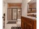 Bathroom with a brick lined shower, rustic vanity and black and white rug at 6029 Shadburn Ferry Rd, Buford, GA 30518