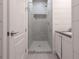Clean bathroom with a glass-enclosed shower and white vanity with stone countertop at 6029 Shadburn Ferry Rd, Buford, GA 30518