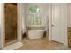 Bathroom featuring standalone tub, shower, tiled floors and window with shades allowing natural light to enter at 6029 Shadburn Ferry Rd, Buford, GA 30518
