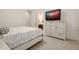 Bright bedroom featuring a white dresser with a mounted television and an ensuite bathroom for added convenience at 6029 Shadburn Ferry Rd, Buford, GA 30518
