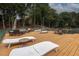Spacious wooden deck features lounge chairs, dining tables, and comfortable seating, ideal for lakeside relaxation at 6029 Shadburn Ferry Rd, Buford, GA 30518