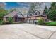 Attractive brick home exterior with a large driveway and well-maintained landscaping at 6029 Shadburn Ferry Rd, Buford, GA 30518