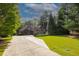 Well-maintained home featuring a lush green lawn, mature trees, and a long driveway for plenty of parking at 6029 Shadburn Ferry Rd, Buford, GA 30518