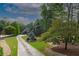 Scenic view of a home with a long driveway, lush greenery, and mature trees providing privacy and beauty at 6029 Shadburn Ferry Rd, Buford, GA 30518