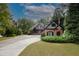 Charming brick and wood home with lush green landscaping and long driveway, a perfect Gathering residence at 6029 Shadburn Ferry Rd, Buford, GA 30518