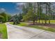 Picturesque long driveway lined by beautiful trees and landscaping leading to a well-maintained home at 6029 Shadburn Ferry Rd, Buford, GA 30518