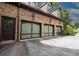 Three-car garage featuring unique glass panel doors, plus a side entrance at 6029 Shadburn Ferry Rd, Buford, GA 30518