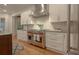 Well-equipped kitchen featuring a stainless steel Wolf range and white cabinetry at 6029 Shadburn Ferry Rd, Buford, GA 30518