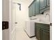 Modern laundry room featuring sleek cabinetry, a sink, and updated washer and dryer for added convenience at 6029 Shadburn Ferry Rd, Buford, GA 30518
