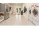 Spacious laundry room featuring modern appliances, tile flooring, refrigerator, and ample storage at 6029 Shadburn Ferry Rd, Buford, GA 30518