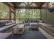 Inviting outdoor lounge with sectional sofa, vaulted wood ceiling, and views of the surrounding trees at 6029 Shadburn Ferry Rd, Buford, GA 30518