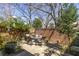 Charming stone patio with outdoor dining set surrounded by lush greenery and a brick wall at 238 15Th Ne St # 18, Atlanta, GA 30309
