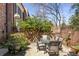 Inviting patio with a dining table set, framed by a brick wall and flourishing greenery, perfect for gatherings at 238 15Th Ne St # 18, Atlanta, GA 30309