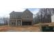 Two-story home featuring a gray exterior, brick accents, and an open two-car garage at 6005 Spring Way, Stonecrest, GA 30038