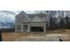 Two-story home featuring brick and siding, with an attached two-car garage on an unfinished lot at 6015 Spring Way, Stonecrest, GA 30038