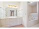 Bathroom featuring a double sink vanity, large mirror, and soaking tub at 950 Sundew Se Dr, Conyers, GA 30013