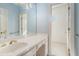 Bright bathroom featuring a vanity with gold fixtures and blue wallpaper at 950 Sundew Se Dr, Conyers, GA 30013