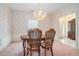 Classic dining room features elegant wallpaper, chandelier, and carpeted floors at 950 Sundew Se Dr, Conyers, GA 30013