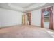 Spacious primary bedroom with decorative tray ceiling, carpet, and light-filled windows at 950 Sundew Se Dr, Conyers, GA 30013
