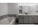 Bright bathroom with double vanity, large mirror, soaking tub and gray accents at 1049 Brandsford Nw St # 27-01, Atlanta, GA 30318