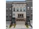 Charming three-story townhouse with brick and neutral siding, featuring a balcony and attached garage at 1049 Brandsford Nw St # 27-01, Atlanta, GA 30318