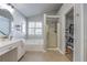 Bathroom with granite countertops, walk-in shower, soaker tub, linen closet, and tile floors at 1510 Ridgemill Ter, Dacula, GA 30019