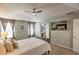 Bedroom with tray ceiling, large windows with curtains, wall mounted TV, and ensuite bath access at 1510 Ridgemill Ter, Dacula, GA 30019