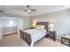 Bedroom with large window, ceiling fan, tray ceiling, and two bedside tables with lamps at 1510 Ridgemill Ter, Dacula, GA 30019