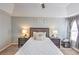 Bedroom featuring neutral walls, tray ceiling, ceiling fan, and bedside tables with lamps at 1510 Ridgemill Ter, Dacula, GA 30019