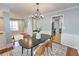Charming dining room with modern light fixture, wainscotting, and decorative rug at 1510 Ridgemill Ter, Dacula, GA 30019