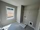 Functional laundry room with tile flooring, utility sink connection, window, and storage at 316 Willow Cv, Canton, GA 30114