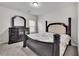 Well-lit bedroom with a four-poster bed, dark wood furniture, and plush carpeting at 681 Deer Springs Way, Loganville, GA 30052