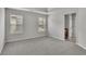 Spacious bedroom featuring two windows, neutral paint, and a tray ceiling at 681 Deer Springs Way, Loganville, GA 30052