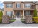 Inviting front porch with brick pillars and a 'welcome' sign, enhanced by lush landscaping at 681 Deer Springs Way, Loganville, GA 30052