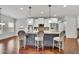 Kitchen island with pendant lighting and seating, adjacent to a dining area with wood floors at 681 Deer Springs Way, Loganville, GA 30052