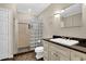 Bright bathroom features a glass-block shower, granite countertops, and tile flooring at 7467 Portbury Park Ln, Suwanee, GA 30024