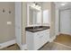 Bathroom featuring a modern white vanity with granite counters, a large mirror, and neutral paint at 7467 Portbury Park Ln, Suwanee, GA 30024