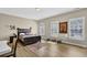 Comfortable bedroom with wood floors, neutral walls, and bright natural light at 7467 Portbury Park Ln, Suwanee, GA 30024