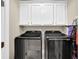 Modern laundry room with matching appliances and upper cabinets for extra storage at 7467 Portbury Park Ln, Suwanee, GA 30024