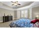 Sun-filled main bedroom features a tray ceiling, hardwood floors, and a large dresser at 7467 Portbury Park Ln, Suwanee, GA 30024