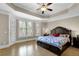 Bright main bedroom with tray ceilings, plantation shutters, and hardwood floors at 7467 Portbury Park Ln, Suwanee, GA 30024